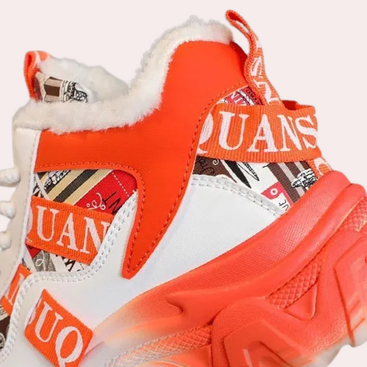 Witte en oranje sneaker met bontvoering en opvallend patroon, merknaam "QUANS" zichtbaar. Trendy sportschoen, modieus design, comfortabele pasvorm.