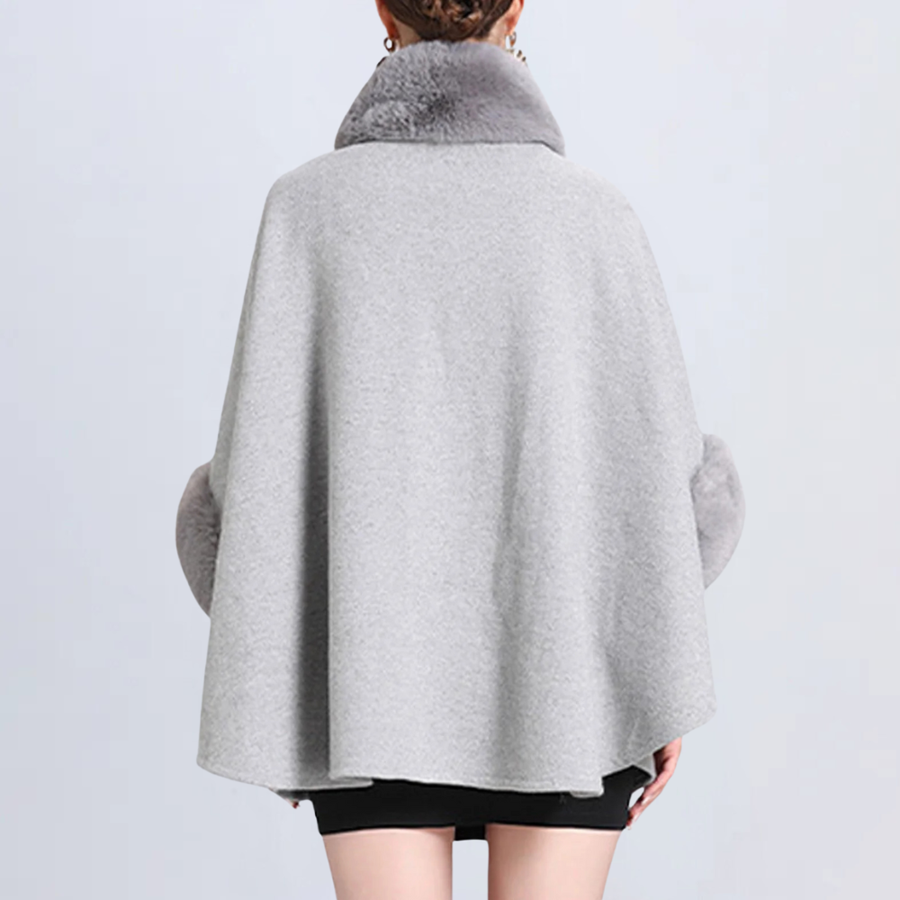Grijze damescape met bontkraag, elegante wintermode, stijlvolle warme mantel, trendy kleding voor koude seizoenen, modieuze damesoutfit.