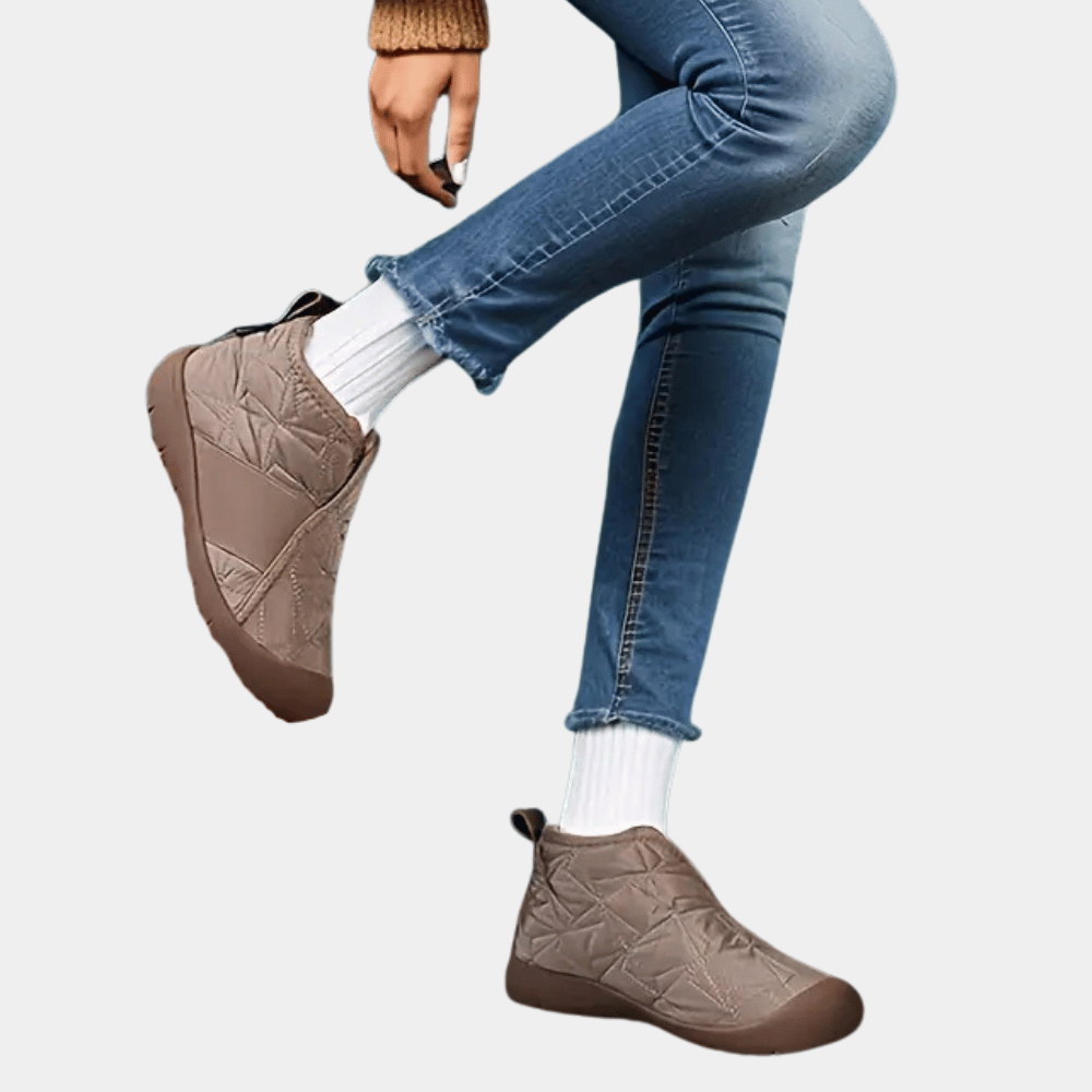 Beige winterlaarzen voor dames, waterdicht en gevoerd, gedragen met blauwe jeans en witte sokken. Comfortabele en warme schoenen voor koud weer.