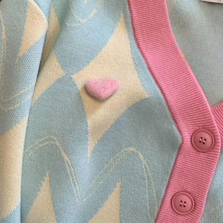 Roze en blauwe gebreide trui met hartvormige knoop, pastelkleurig patroon, damesmode, trendy kleding, comfortabele en stijlvolle outfit.