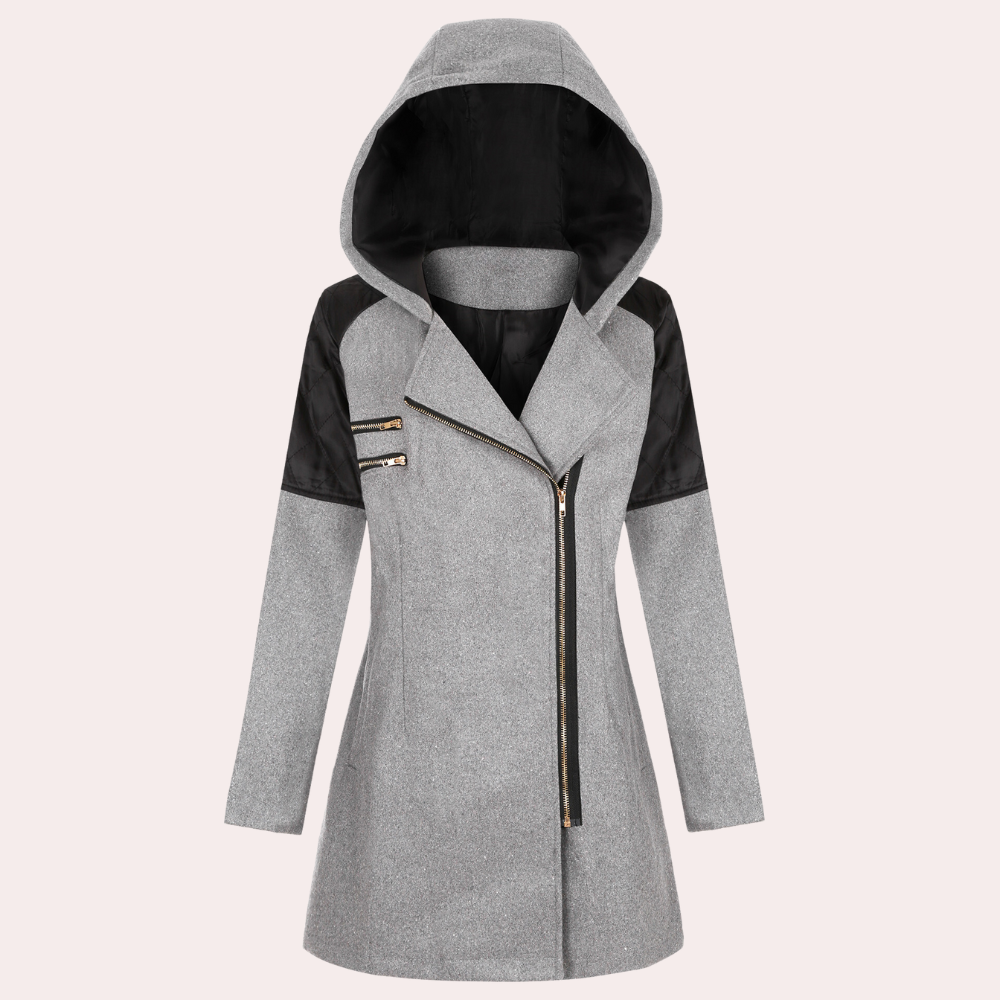 Grijze damesjas met capuchon, asymmetrische ritssluiting en zwarte schouderaccenten. Modieuze winterjas voor dames, ideaal voor koude seizoenen.