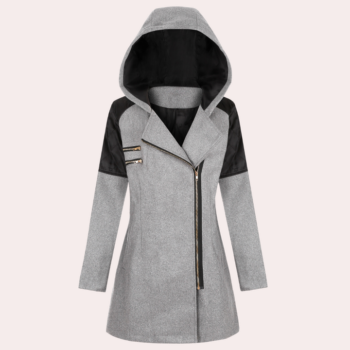 Grijze damesjas met capuchon, asymmetrische ritssluiting en zwarte schouderaccenten. Modieuze winterjas voor dames, ideaal voor koude seizoenen.