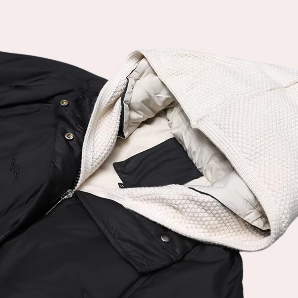 Zwart-witte gewatteerde jas met capuchon, ritssluiting en knopen. Ideaal voor wintermode, biedt warmte en stijl. Unisex ontwerp, trendy en functioneel.
