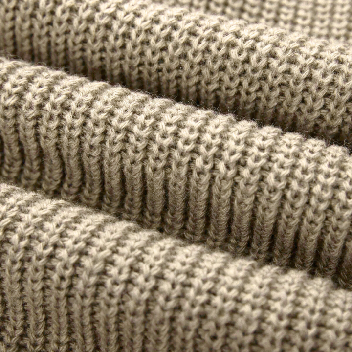 Beige gebreide stof close-up, textuur van wol, geschikt voor truien en winterkleding. Zachte, warme breisel voor mode en interieur.
