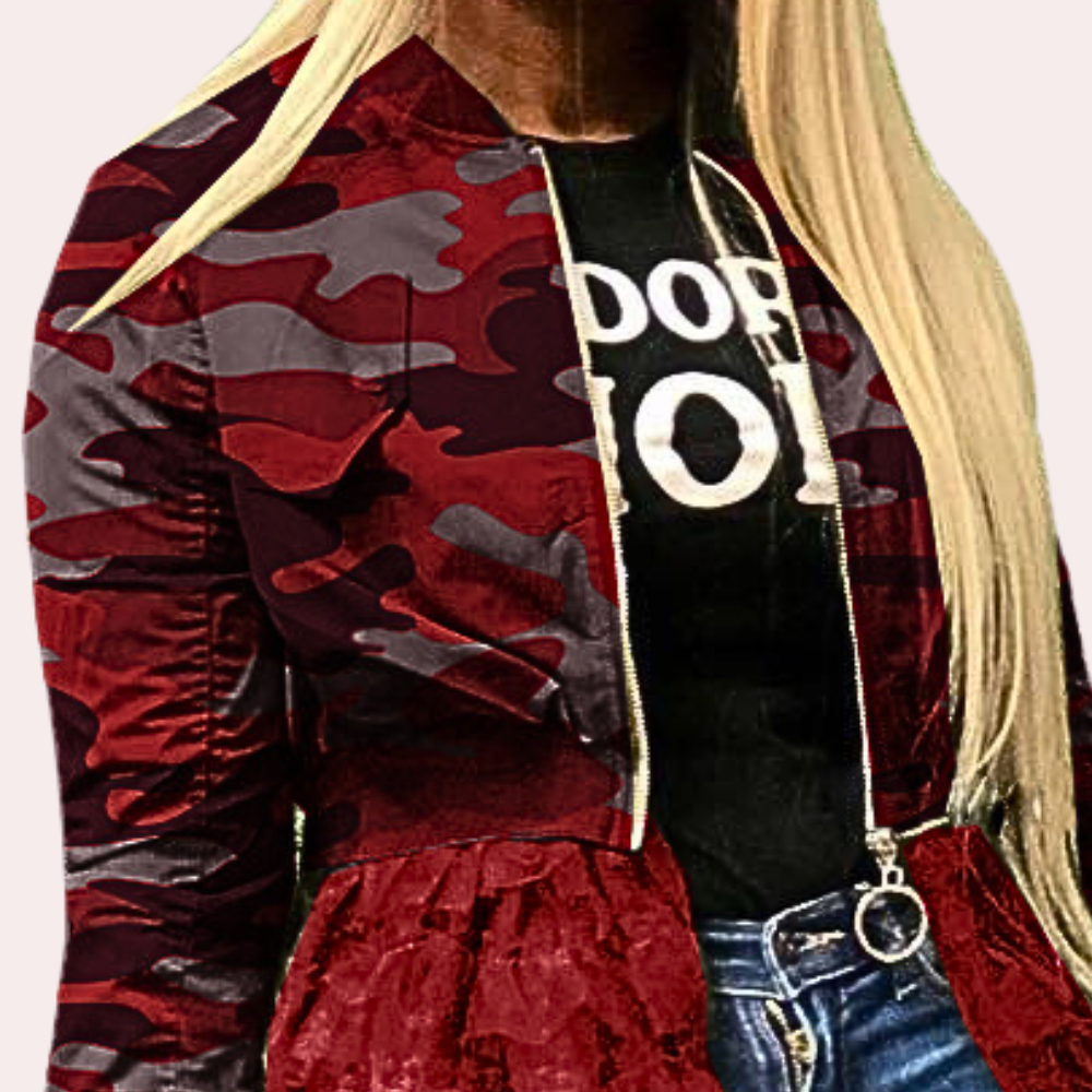Rood camouflage bomberjack met rits, gedragen door vrouw met blond haar, zwarte T-shirt en blauwe jeans. Modieuze dameskleding, urban stijl.
