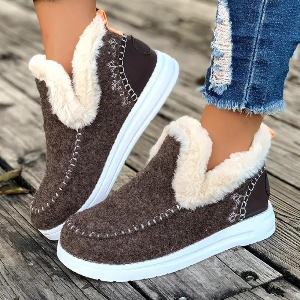 Bruine winterlaarzen met witte voering, comfortabele dames schoenen, warme bontvoering, casual stijl, perfect voor koude seizoenen, op houten vloer.