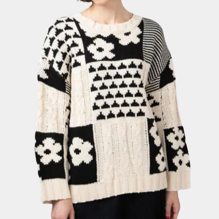 Zwart-witte gebreide trui met bloemen- en geometrische patronen, lange mouwen en ronde hals. Modieuze damestrui, herfst- en winterkleding.