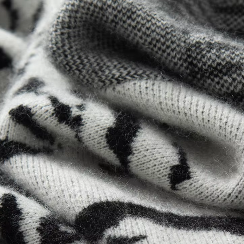 Zachte zwart-witte kasjmier sjaal met abstract patroon, close-up textuur. Luxe winteraccessoire, warme en stijlvolle mode voor koude dagen.