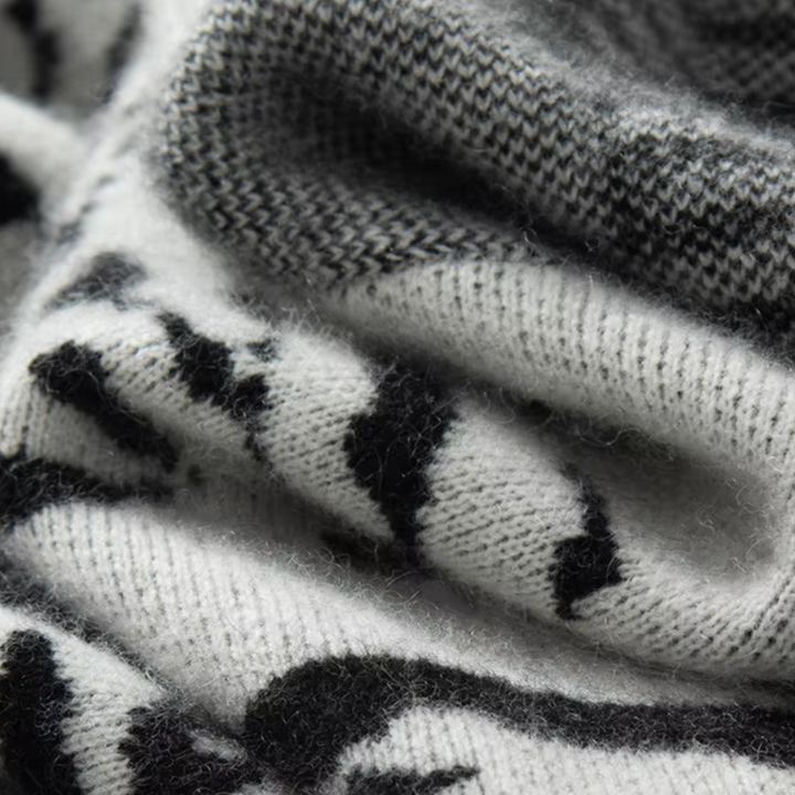 Zachte zwart-witte kasjmier sjaal met abstract patroon, close-up textuur. Luxe winteraccessoire, warme en stijlvolle mode voor koude dagen.
