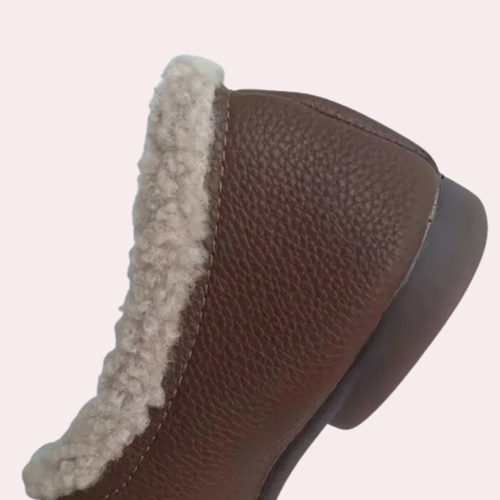 Bruine leren laars met schapenvacht voering, close-up. Wintermode, warme schoenen, stijlvol design, comfortabele dameslaarzen.