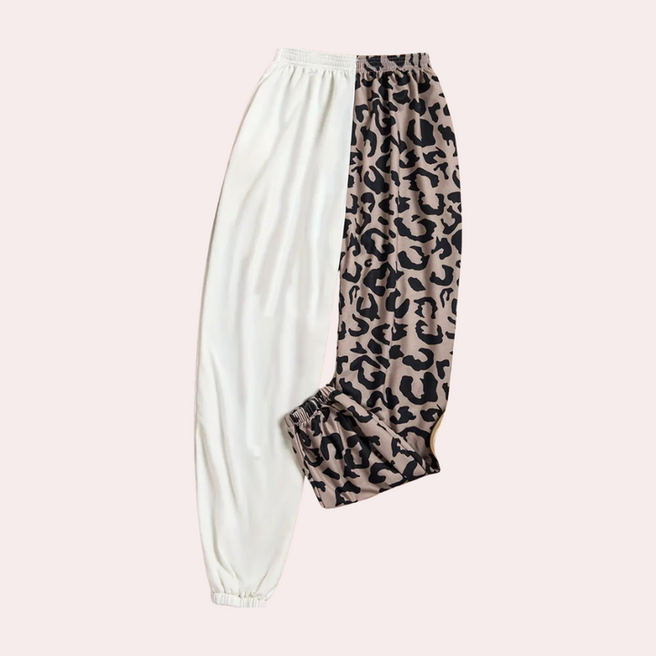 Tweekleurige joggingbroek met luipaardprint en effen wit, elastische tailleband en boorden. Trendy damesmode, comfortabele loungewear.