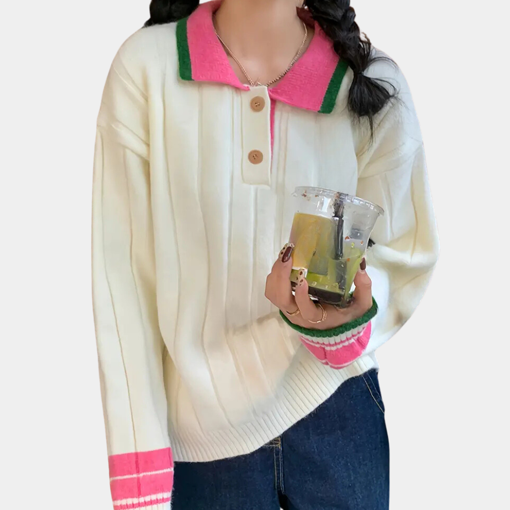 Vrouw in witte trui met roze en groene accenten, houdt een plastic beker. Casual mode, herfstkleding, trendy damestrui, comfortabele outfit.