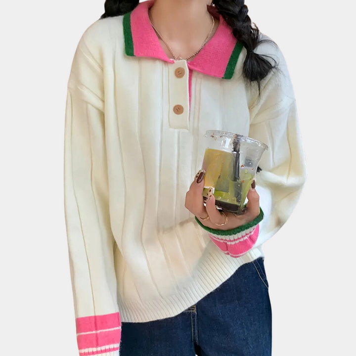 Vrouw in witte trui met roze en groene accenten, houdt een plastic beker. Casual mode, herfstkleding, trendy damestrui, comfortabele outfit.