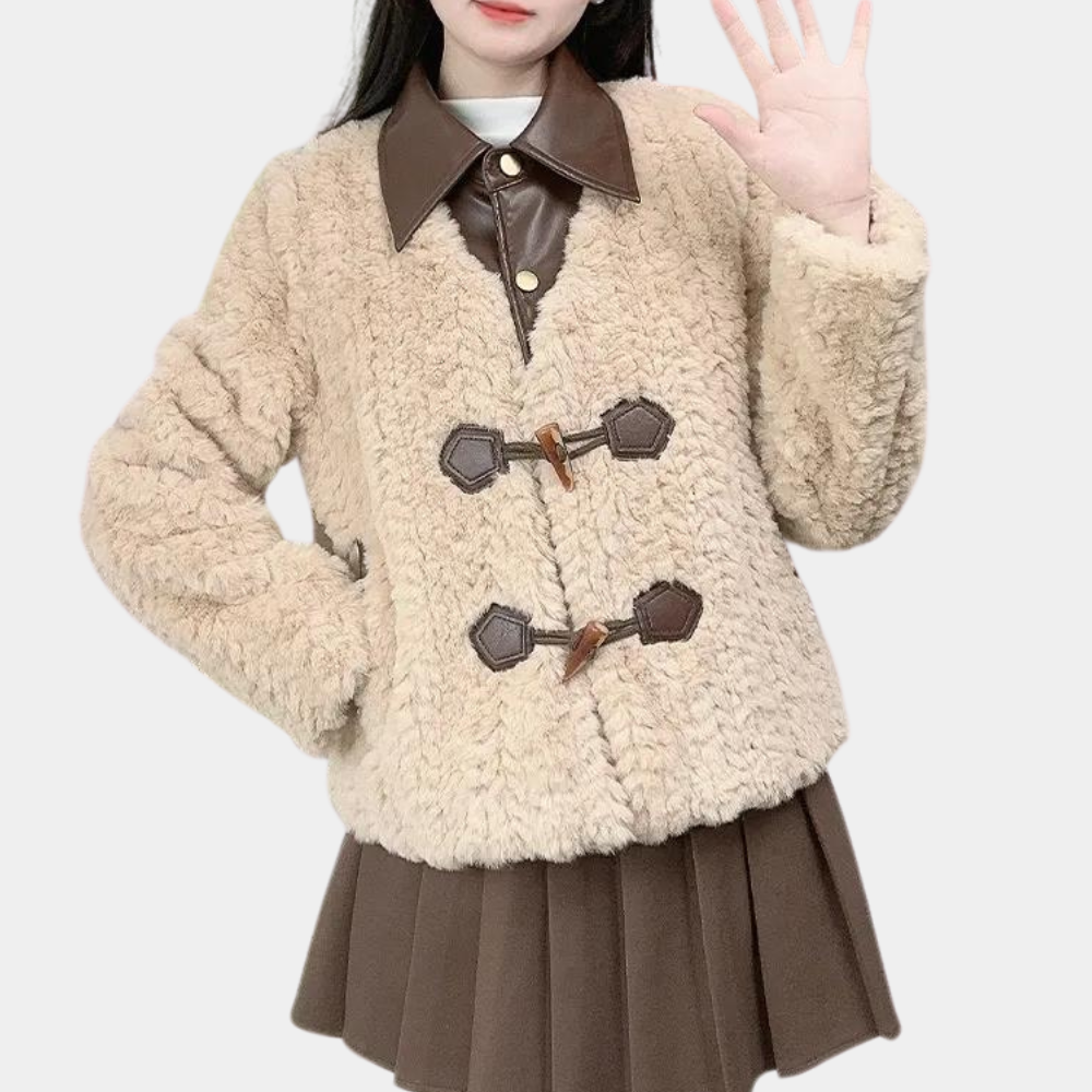 Vrouw in beige teddyjas met bruine leren kraag en knopen, gecombineerd met bruine plooirok. Modieuze winterkleding, trendy damesmode.