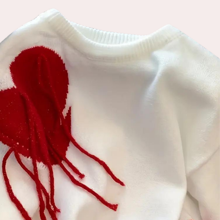 Witte trui met rood hartontwerp en franjes, trendy damesmode, comfortabele gebreide stof, perfect voor casual winteroutfits.
