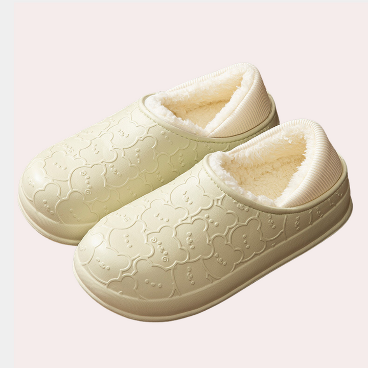 Crèmekleurige pantoffels met schattig beermotief en zachte voering, ideaal voor comfort en warmte. Perfecte huispantoffels voor koude dagen.