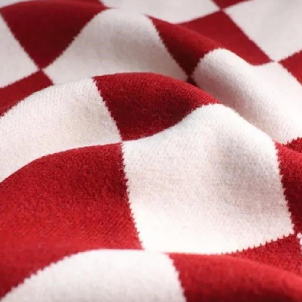 Rood-wit geruite wollen deken, close-up textuur. Zachte, warme plaid voor interieurdecoratie, perfect voor gezellige winteravonden.
