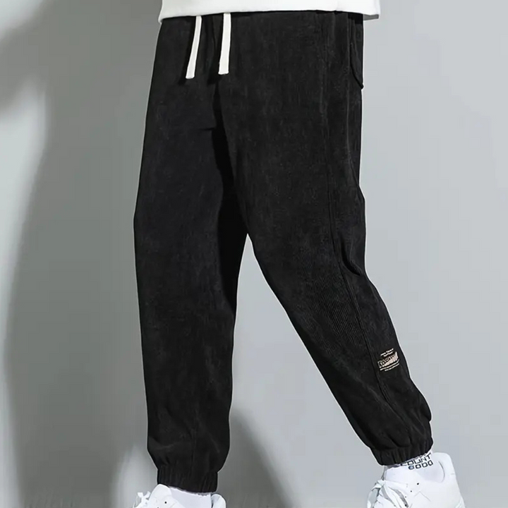 Zwarte corduroy joggingbroek voor heren, casual stijl, met elastische tailleband en enkelboorden, ideaal voor dagelijks gebruik en sportieve activiteiten.