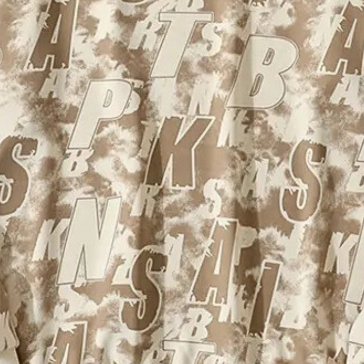 Beige en bruine stof met abstracte letters en patronen, ideaal voor moderne interieurdecoratie en textielontwerp.