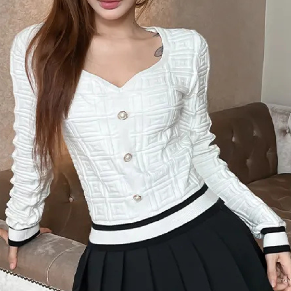 Vrouw draagt witte gewatteerde trui met knopen, gecombineerd met zwarte rok. Modieuze dameskleding, herfst-winter stijl, elegant design.