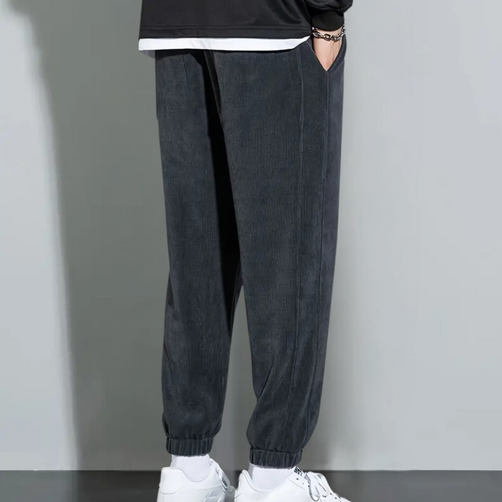 Donkergrijze corduroy joggingbroek voor heren, casual en comfortabel, met elastische tailleband en enkels. Perfect voor dagelijks gebruik.