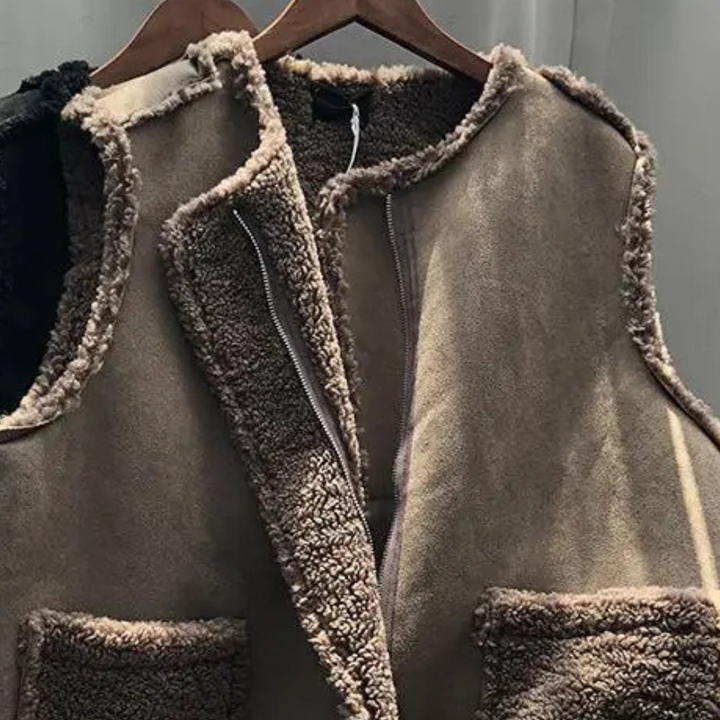 Bruine schapenvacht gilet op houten hanger, warme winterkleding, modieuze damesvest, zachte voering, casual stijl, comfortabele buitenkleding.