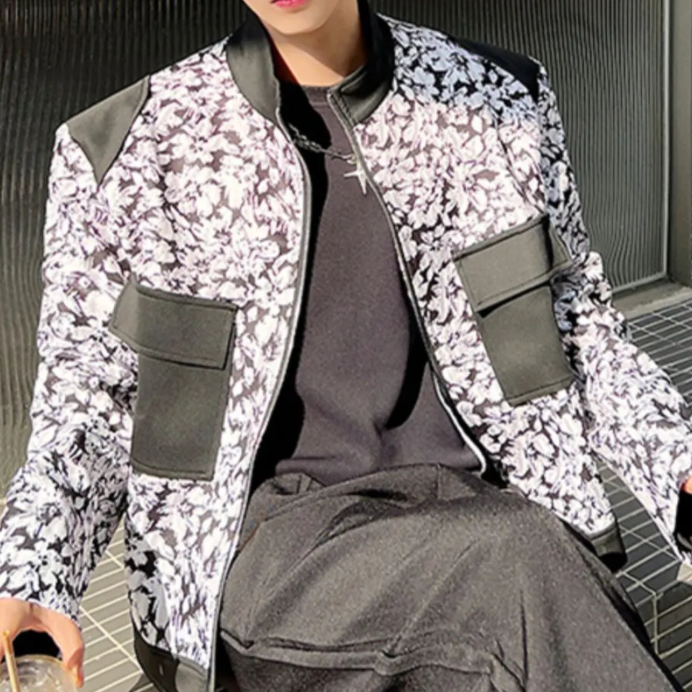 Modieuze zwart-witte bloemenjas met leren accenten, gedragen door een persoon. Trendy herenkleding, streetwear stijl, herfstmode.