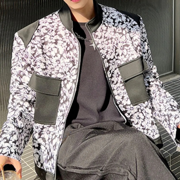 Modieuze zwart-witte bloemenjas met leren accenten, gedragen door een persoon. Trendy herenkleding, streetwear stijl, herfstmode.
