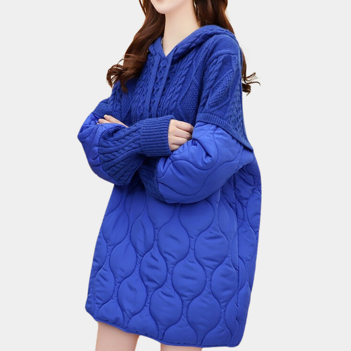 Vrouw in blauwe oversized hoodie met gewatteerde mouwen, modieuze winterkleding, comfortabele en trendy damesmode, casual stijl.
