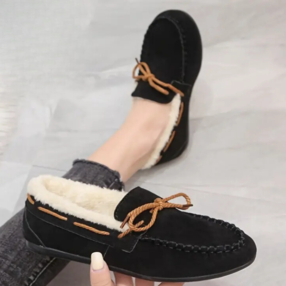Zwarte suède mocassins met witte voering en bruine veters, comfortabele damespantoffels, ideaal voor binnengebruik, warme wintermode.