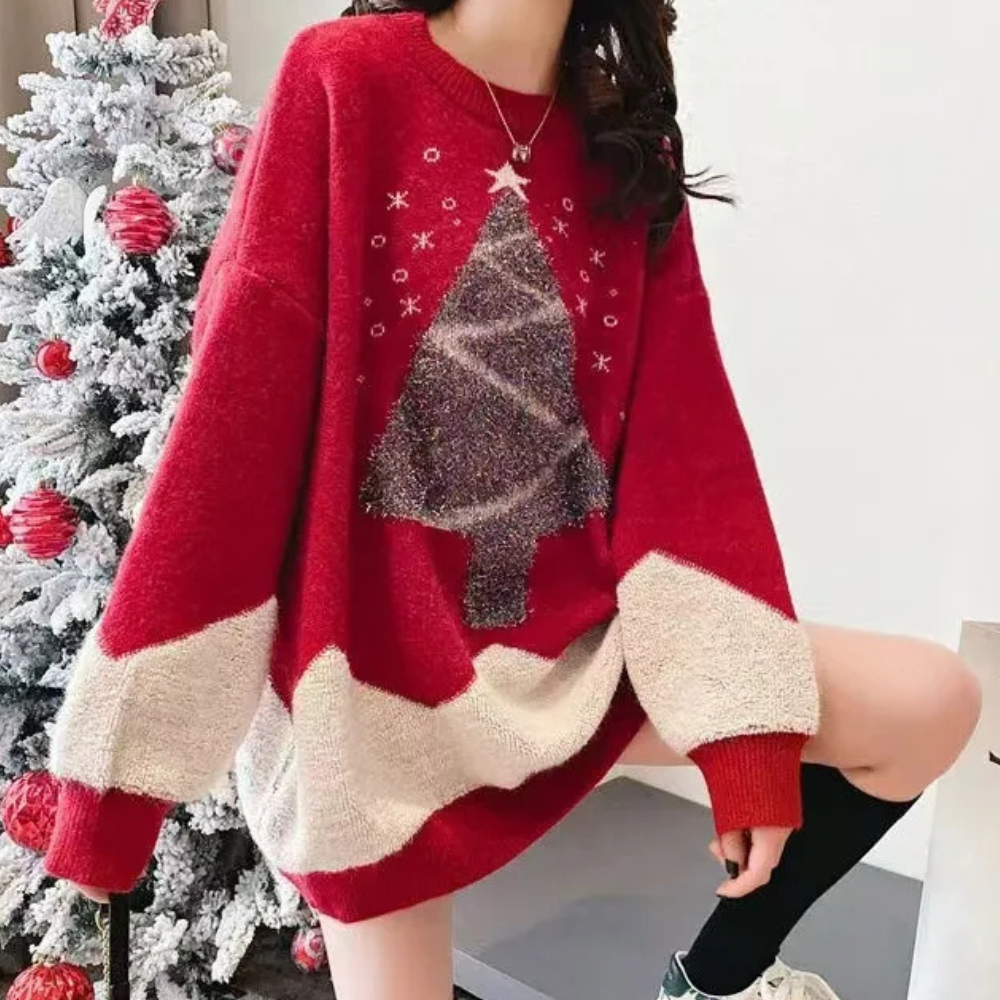 Vrouw in rode kersttrui met kerstboomprint, naast versierde kerstboom. Perfect voor feestdagen, wintermode, kerstkleding.