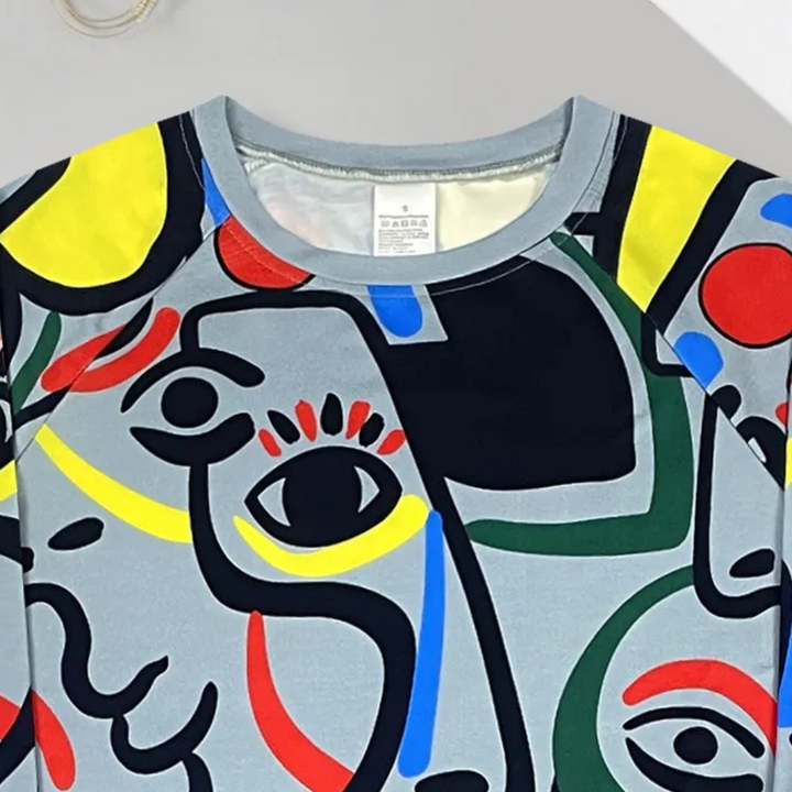 Abstracte kunsttrui met kleurrijke geometrische patronen, waaronder ogen en gezichten, op een grijze achtergrond. Moderne mode, unieke stijl.