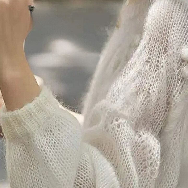 Witte gebreide trui met gedetailleerd patroon, close-up. Zachte, warme damesmode, perfect voor herfst- en winterseizoenen. Comfortabele kledingstijl.