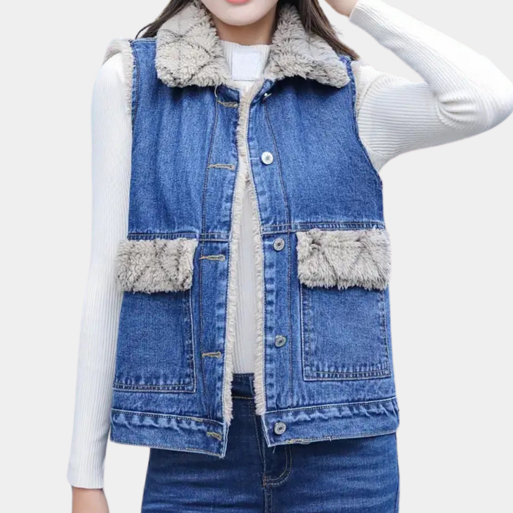 Vrouw draagt blauwe spijkerjas met schapenvacht voering, witte trui eronder. Modieuze winterkleding, casual stijl, denim vest outfit.