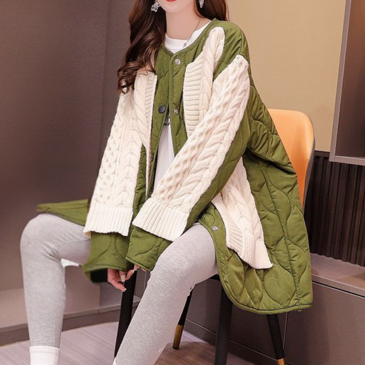Vrouw draagt groene gewatteerde jas met gebreide mouwen, zittend op oranje stoel. Modieuze winterkleding, trendy damesmode, comfortabele outfit.