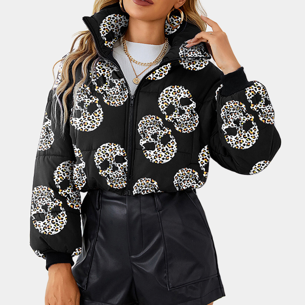 Vrouw in zwarte jas met luipaard schedelprint, hoge kraag en ritssluiting, gecombineerd met zwarte leren shorts. Trendy damesmode, herfst/winter stijl.