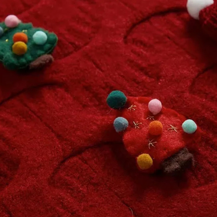 Rode kersttrui met kleurrijke vilten kerstboomdecoraties, perfect voor feestelijke wintermode. Warme, gezellige textuur voor kerstkleding.