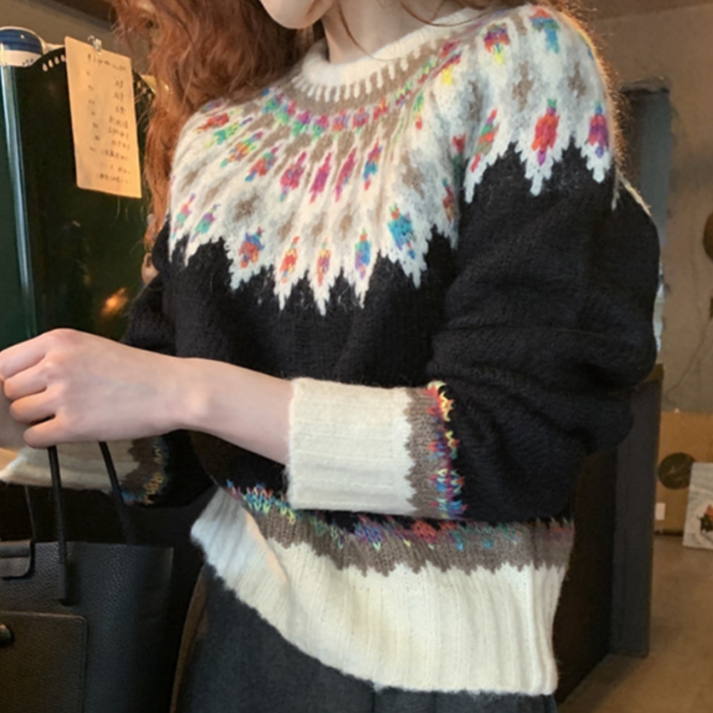 Damestrui met kleurrijk Noors breipatroon, zwart-wit met bloemenaccenten. Perfect voor wintermode en Scandinavische stijl.