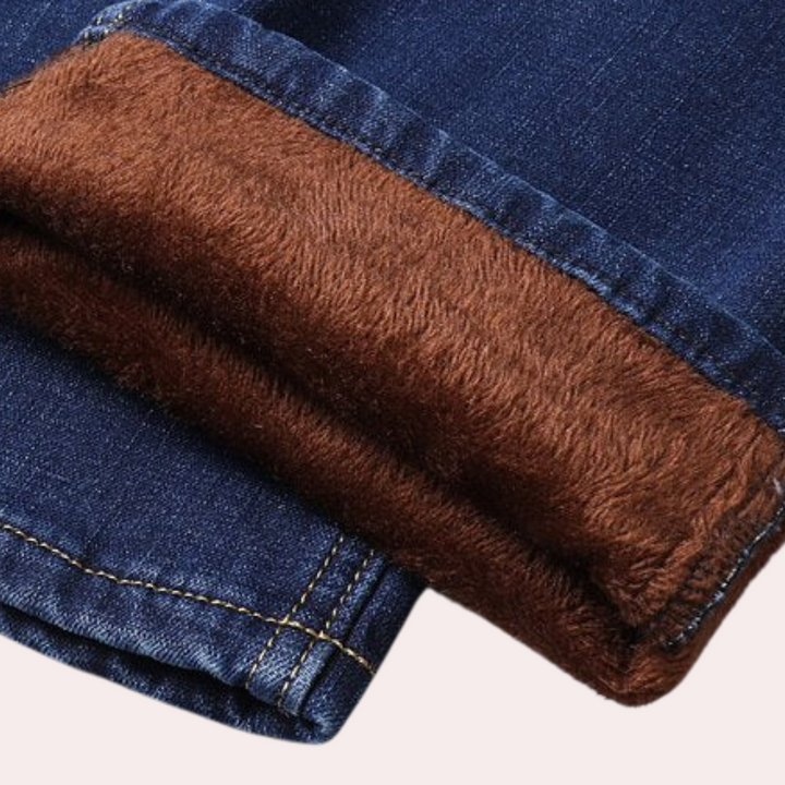 Blauwe spijkerbroek met bruine fleece voering, warme winterkleding, close-up van opgerolde zoom, comfortabele en stijlvolle jeans voor koud weer.