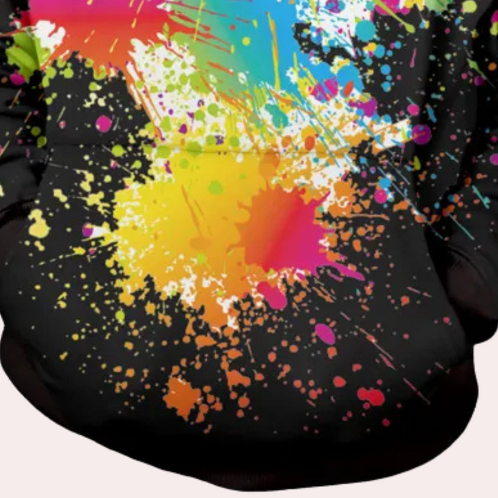 Zwarte hoodie met kleurrijke verfspetters, regenboogdesign, unisex mode, streetwear stijl, opvallende kleding, creatieve print, casual outfit.