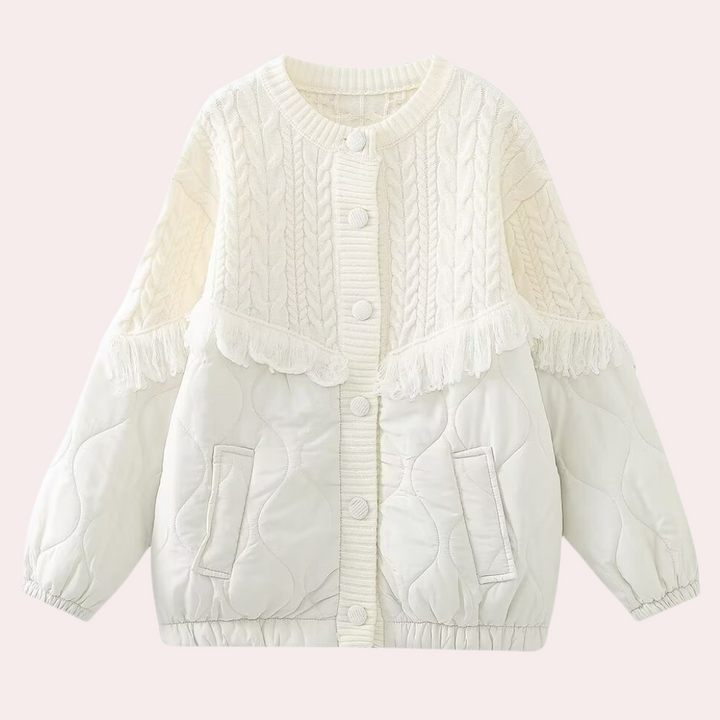 Witte gewatteerde kinderjas met kabelgebreide details en franjes, knoopsluiting en zakken. Perfect voor wintermode en warme kinderkleding.