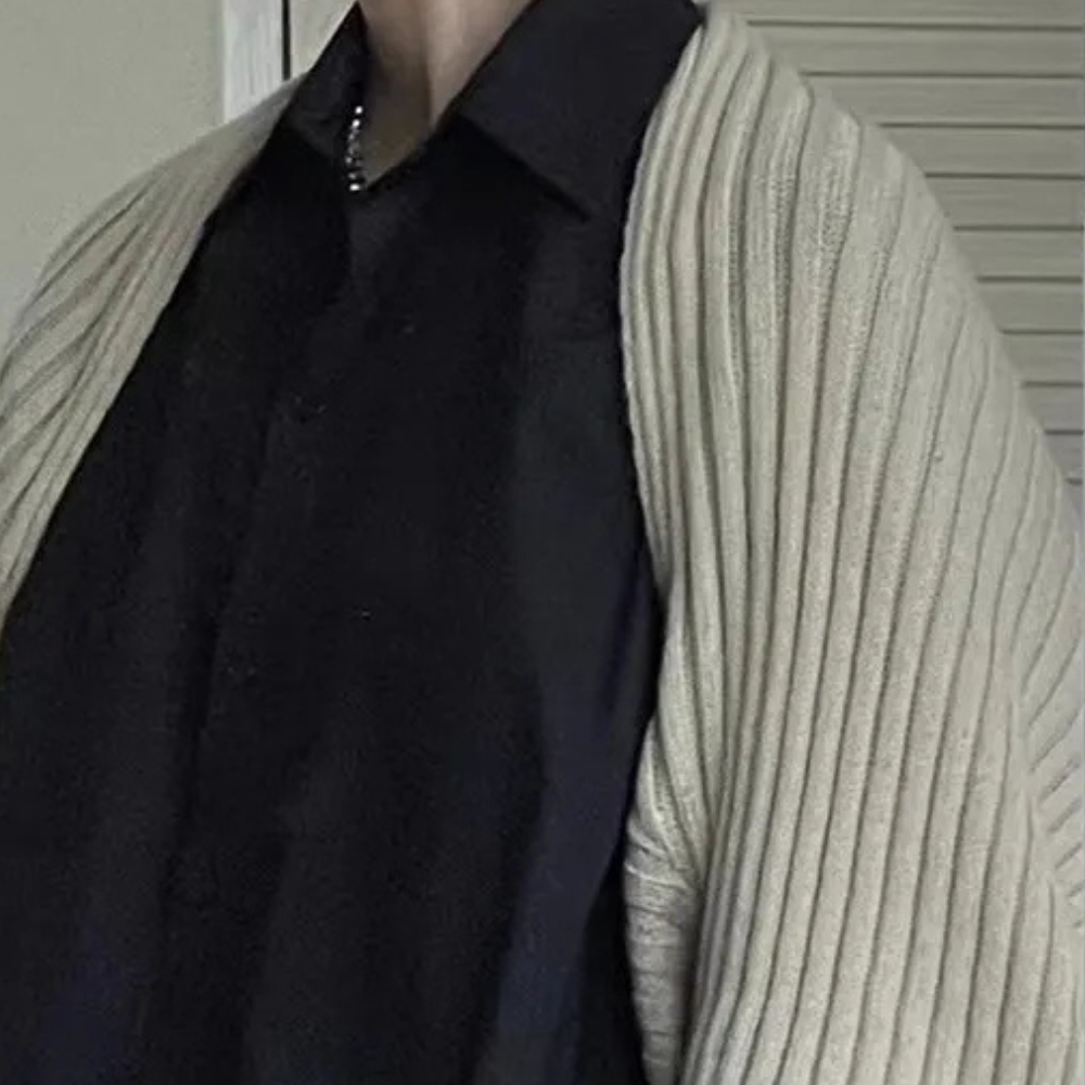 Man in zwarte blouse met beige geribbelde trui over schouders, stijlvolle herenkleding, moderne mode, casual chique look, herfstoutfit.