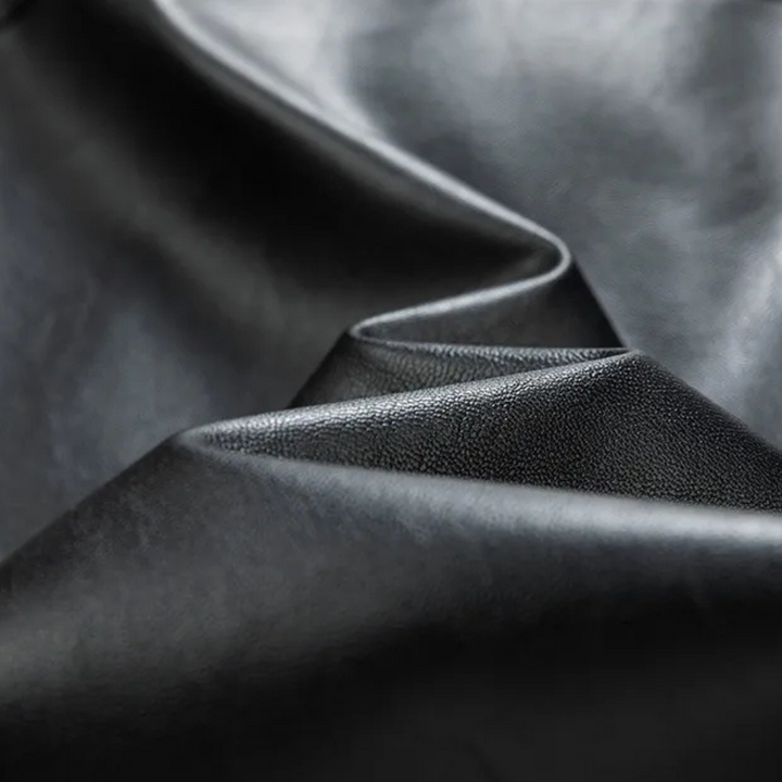 Zwart leer textuur close-up, glad en glanzend oppervlak, geschikt voor luxe meubels, modeaccessoires en interieurontwerp.
