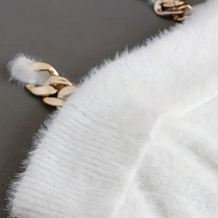 Witte gebreide trui met gouden kettingdetails, zachte textuur, close-up. Modieuze dameskleding, herfst-winter trend, luxe uitstraling.