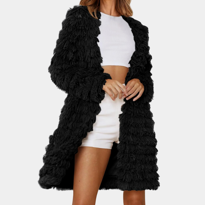 Vrouw in zwarte, pluizige jas en witte crop top met shorts. Modieuze dameskleding, herfst- en winterstijl, trendy outfit voor casual gelegenheden.
