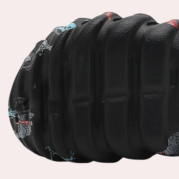 Zwarte, geribbelde schuimroller met kleurrijke patronen, ideaal voor spierherstel en fitness. Geschikt voor yoga en fysiotherapie oefeningen.