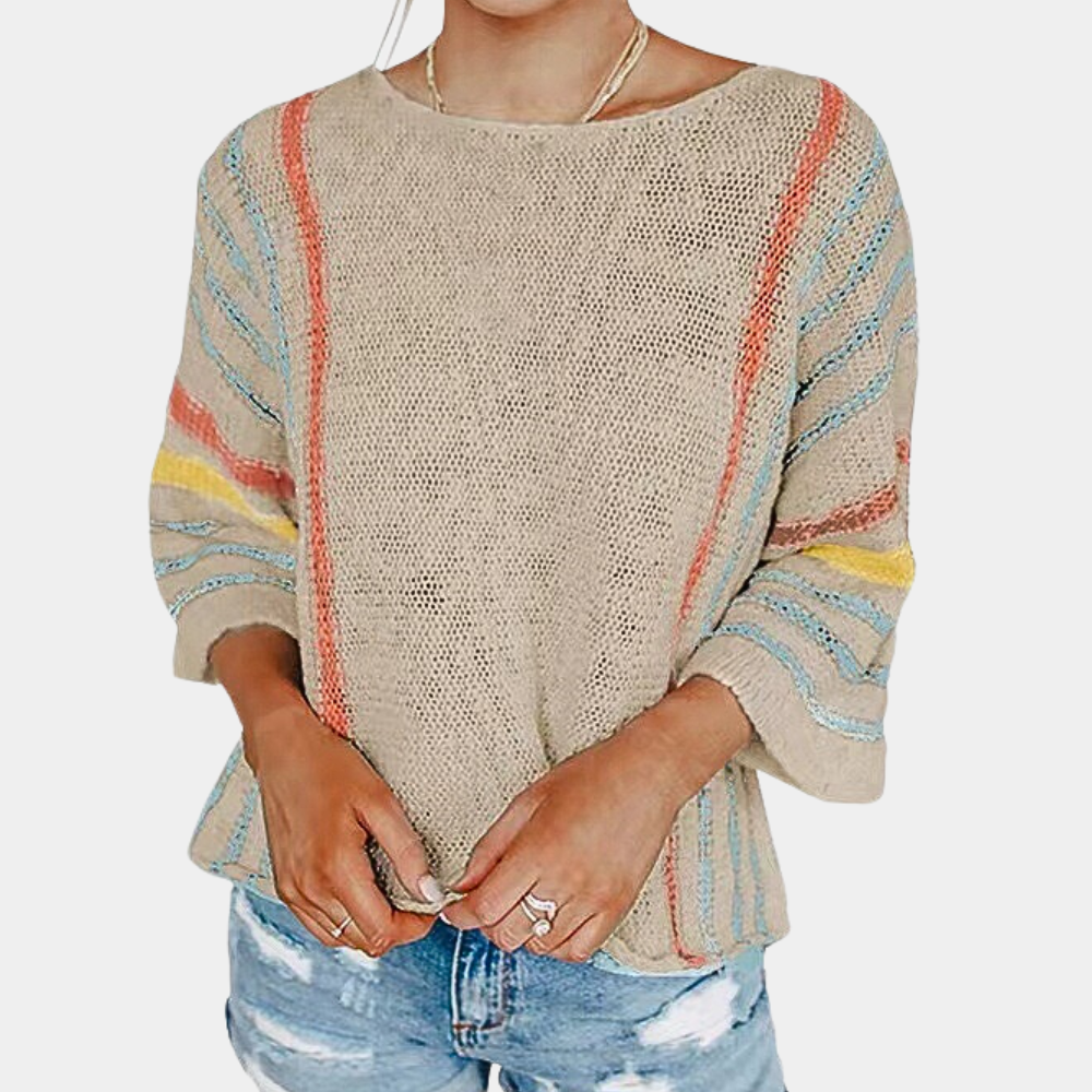 Vrouw draagt beige gebreide trui met kleurrijke strepen, driekwart mouwen en ronde hals, gecombineerd met gescheurde denim shorts.