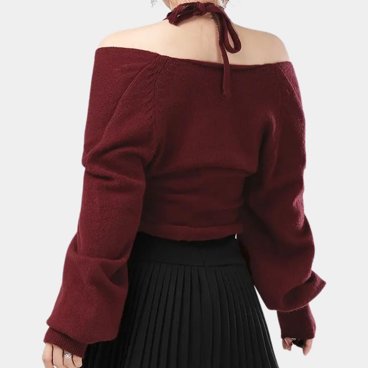 Vrouw in bordeauxrode off-shoulder trui met lange mouwen en geplooide zwarte rok, modieuze herfstkleding, trendy damesmode.