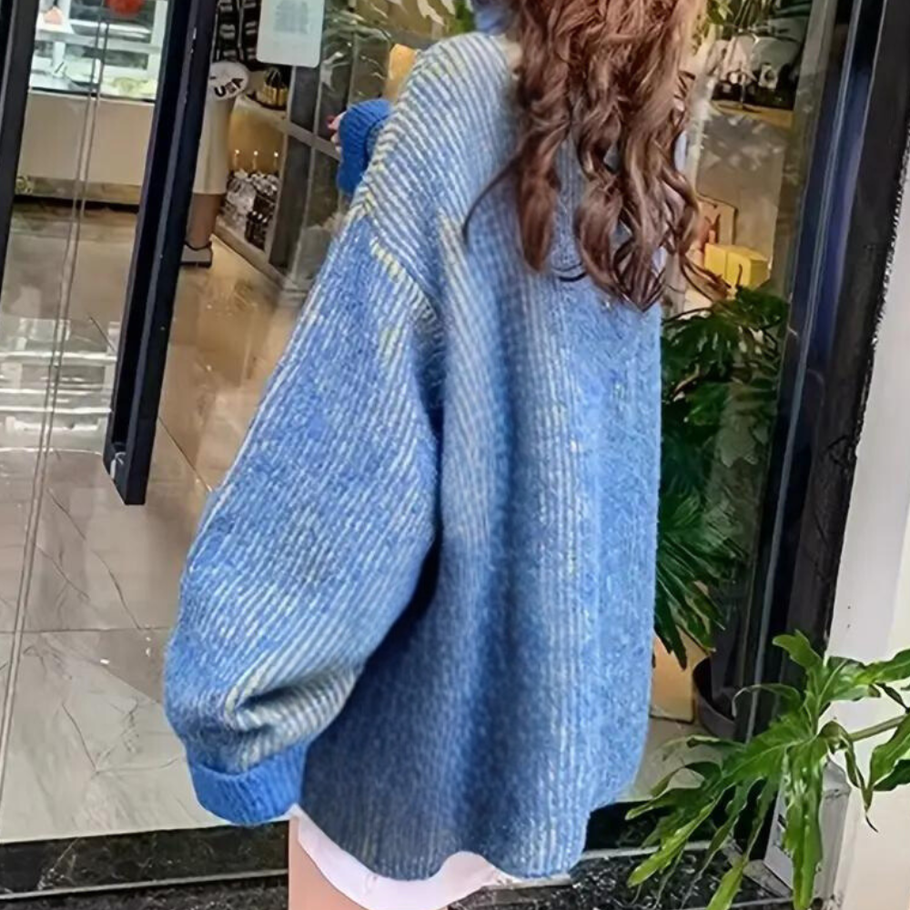 Vrouw in oversized blauwe trui met geribbelde textuur, winkelend in moderne boetiek. Trendy damesmode, casual herfstkleding, winkelinterieur.
