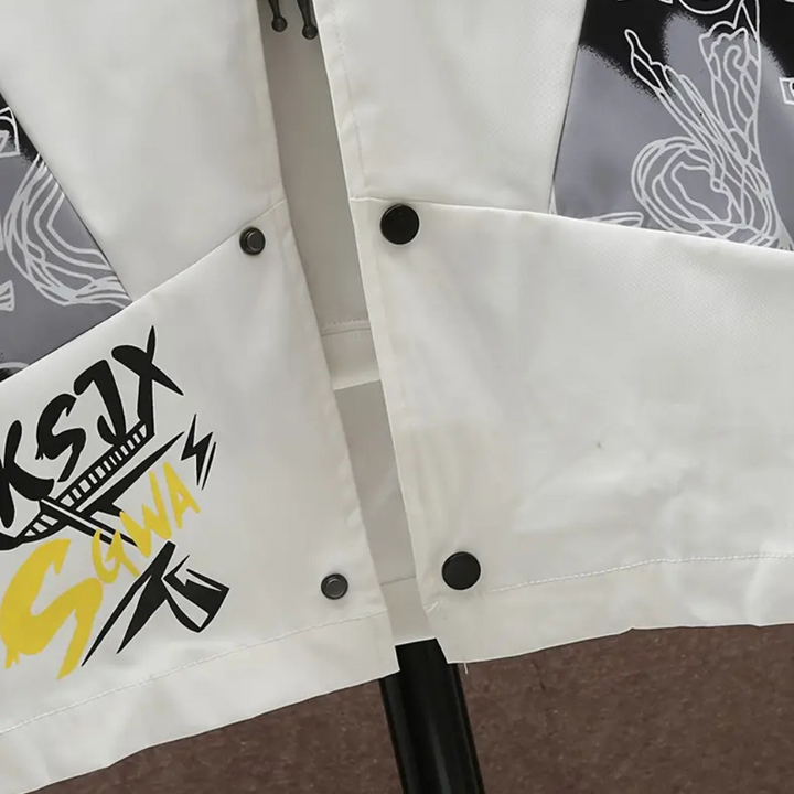 Witte jas met abstracte zwarte en gele grafische print, knopen en ritssluiting. Modieuze streetwear, unisex design, trendy kledingstijl.